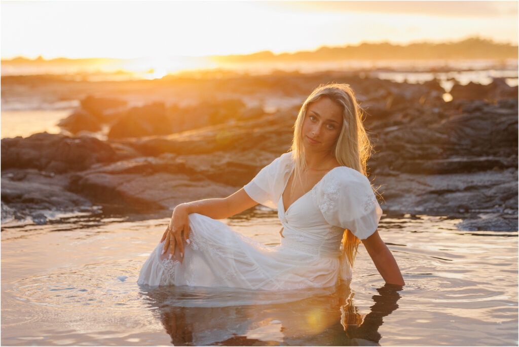 Beach portrait at sunset, in the water in a white dress