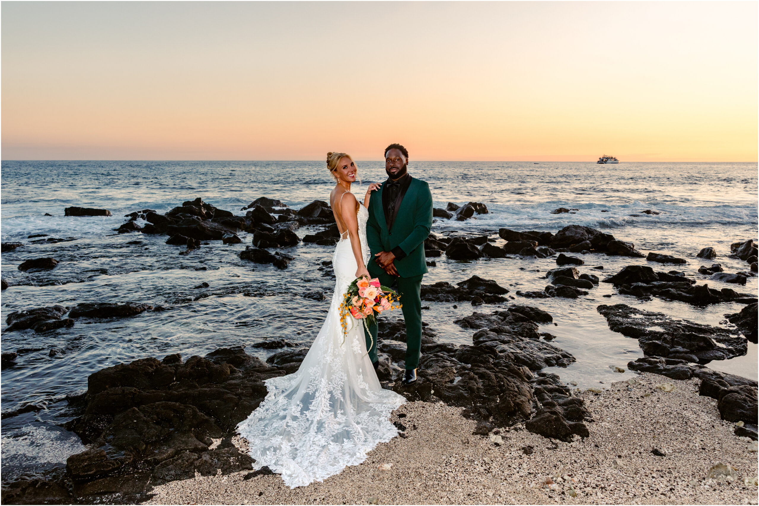 Bride and groom standing on lava rocks after their Hulihe'e Palace wedding in Kona Hawaii
